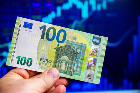 hundreds of euro banknotes on the background of a stock chartの写真素材