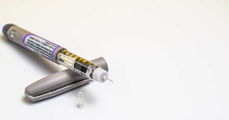 Insulin pen injector. Insulin pen fill with needle on white background. Diabetes Day.の写真素材