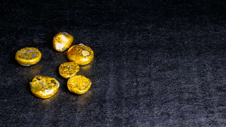 golden buttons, nuggets on a black background. gold recovery
