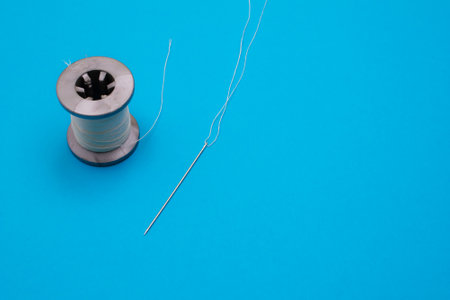 a spool of thread and a needle with a threadの写真素材
