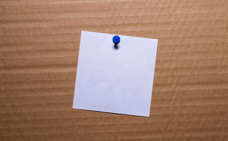 white blank note pinned to a notice board with a paper clip.の写真素材