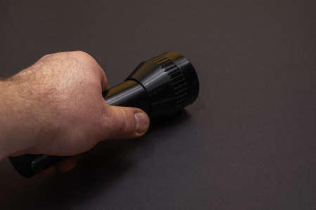 black flashlight held in the hand
