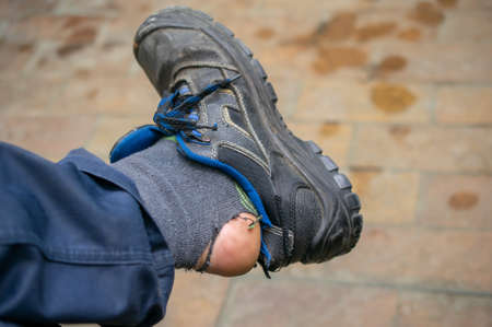 a hole in the sock, the leg of a manual workerの写真素材