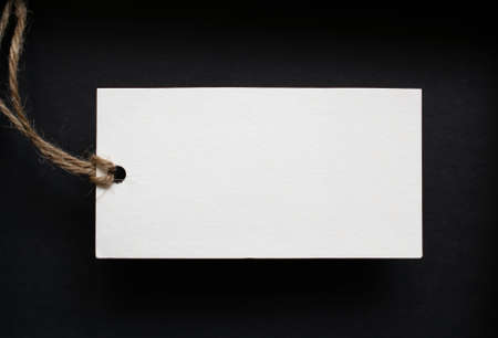 white card with string on black background. place for text.の写真素材