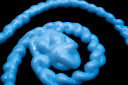 tangle of stream of liquid silicone on a black background