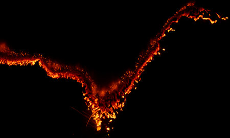 burning paper, glowing edge of paper on a black backgroundの写真素材