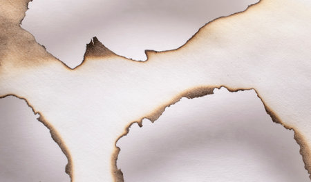 burning paper, glowing edge of paper on a white backgroundの写真素材