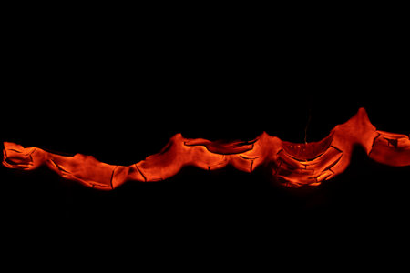 burning paper, glowing edge of paper on a black backgroundの写真素材