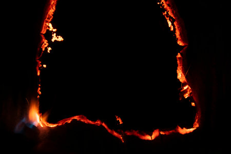 burning paper, glowing edge of paper on a black backgroundの写真素材