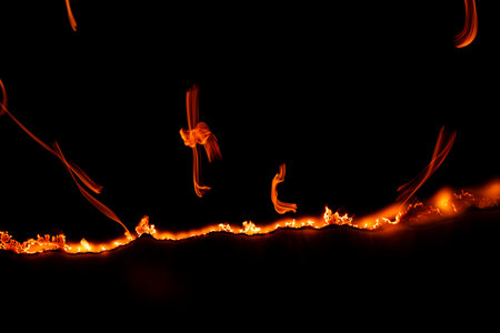 burning paper, glowing edge of paper on a black background