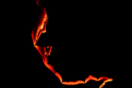 burning paper, glowing edge of paper on a black backgroundの写真素材