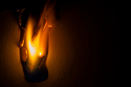 burning paper, glowing edge of paper on a black backgroundの写真素材