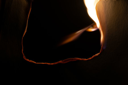 burning paper, glowing edge of paper on a black background