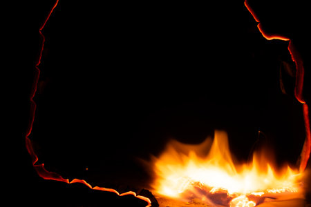 burning paper, glowing edge of paper on a black background