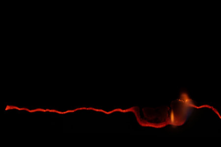 burning paper, glowing edge of paper on a black background
