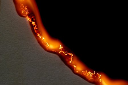 burning paper, glowing edge of paper on a black backgroundの写真素材