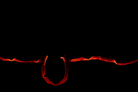 burning paper, glowing edge of paper on a black backgroundの写真素材