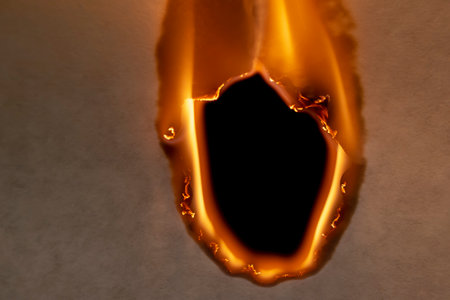 burning paper, glowing edge of paper on a black backgroundの写真素材