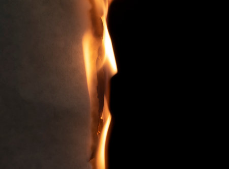 burning paper, glowing edge of paper on a black backgroundの写真素材