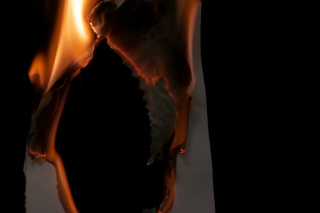 burning paper, glowing edge of paper on a black backgroundの写真素材