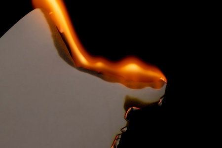 burning paper, glowing edge of paper on a black backgroundの写真素材