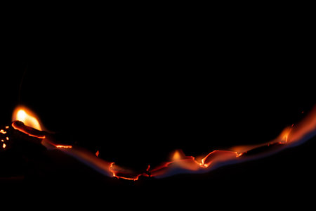 burning paper, glowing edge of paper on a black background