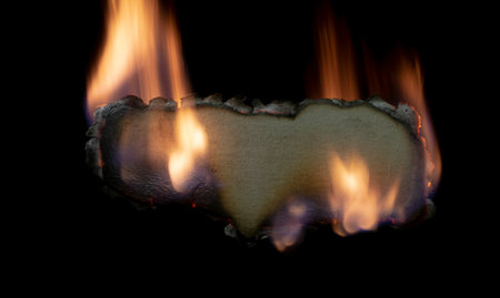 burning paper, glowing edge of paper on a black backgroundの写真素材