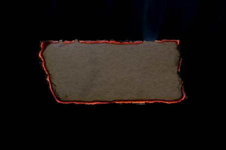 burning paper, glowing edge of paper on a black backgroundの写真素材
