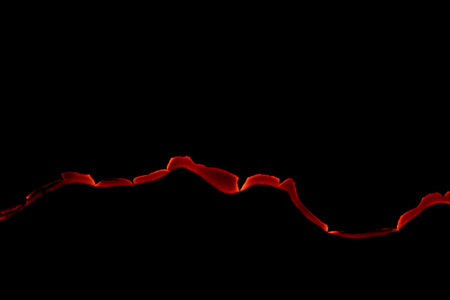 burning paper, glowing edge of paper on a black backgroundの写真素材