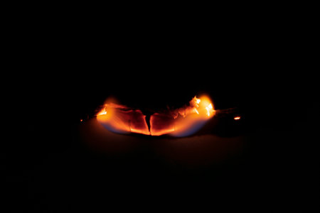 burning paper, glowing edge of paper on a black background