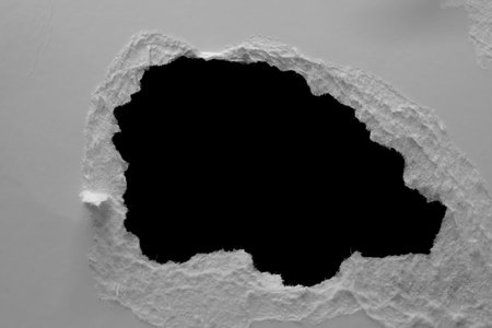 edge of a torn white sheet of paper on a black background, black holeの写真素材