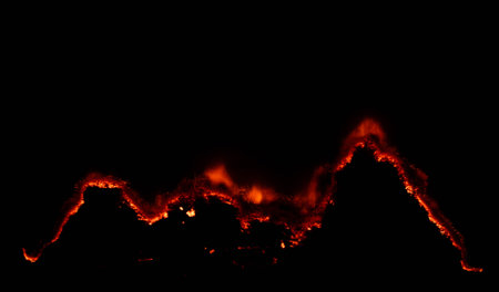 burning paper, glowing edge of paper on a black backgroundの写真素材