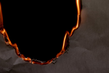 burning paper, glowing edge of paper on a black backgroundの写真素材