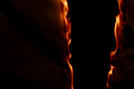 burning paper, glowing edge of paper on a black backgroundの写真素材