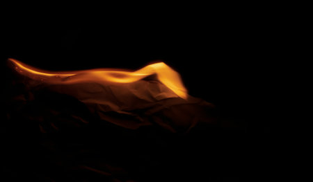 burning paper, glowing edge of paper on a black backgroundの写真素材
