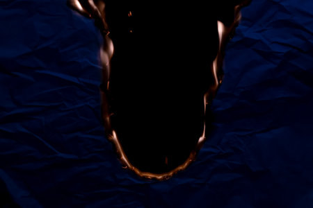 burning paper, glowing edge of paper on a black backgroundの写真素材