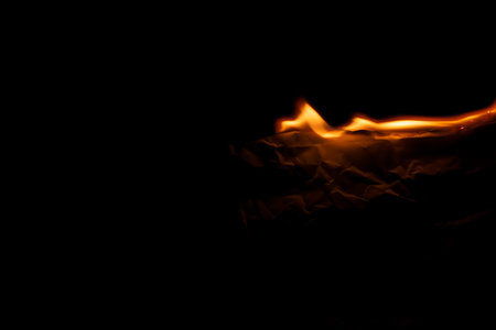 burning paper, glowing edge of paper on a black backgroundの写真素材