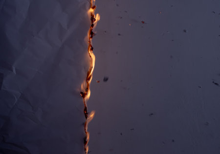 burning paper, glowing edge of paper on a black backgroundの写真素材