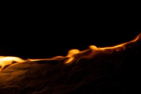 burning paper, glowing edge of paper on a black backgroundの写真素材