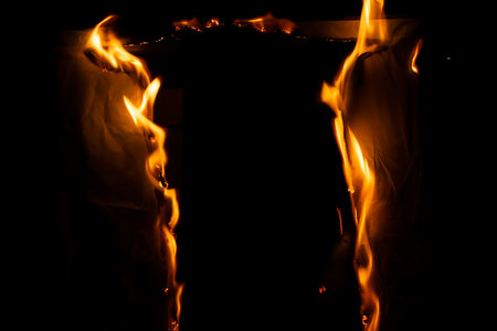 burning paper, glowing edge of paper on a black backgroundの写真素材