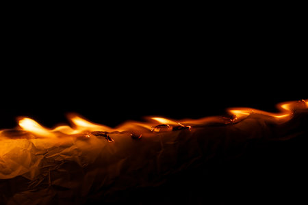 burning paper, glowing edge of paper on a black backgroundの写真素材