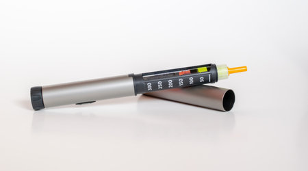 Insulin pen injector. Insulin pen fill with needle on white background.