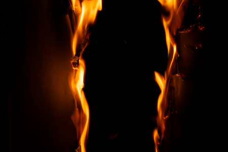 burning paper, glowing edge of paper on a black backgroundの写真素材