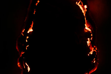 burning paper, glowing edge of paper on a black backgroundの写真素材