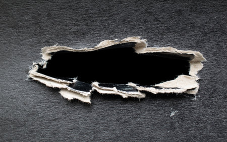 torn hole in black cardboard