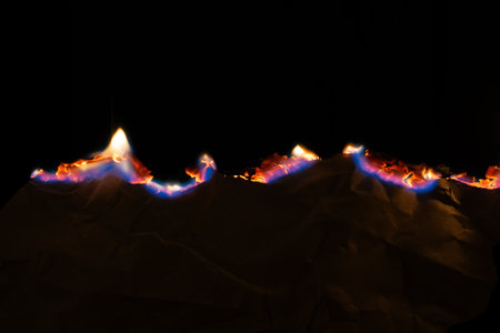 burning paper, glowing edge of paper on a black background