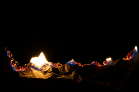 burning paper, glowing edge of paper on a black background