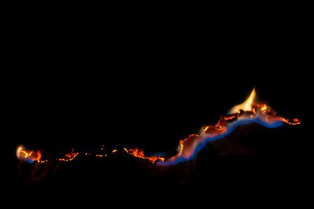 burning paper, glowing edge of paper on a black background
