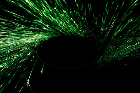 green sparks from the grinder glowing in the darkの写真素材