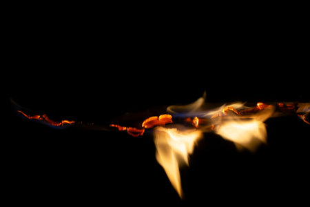 burning paper, glowing edge of paper on a black background